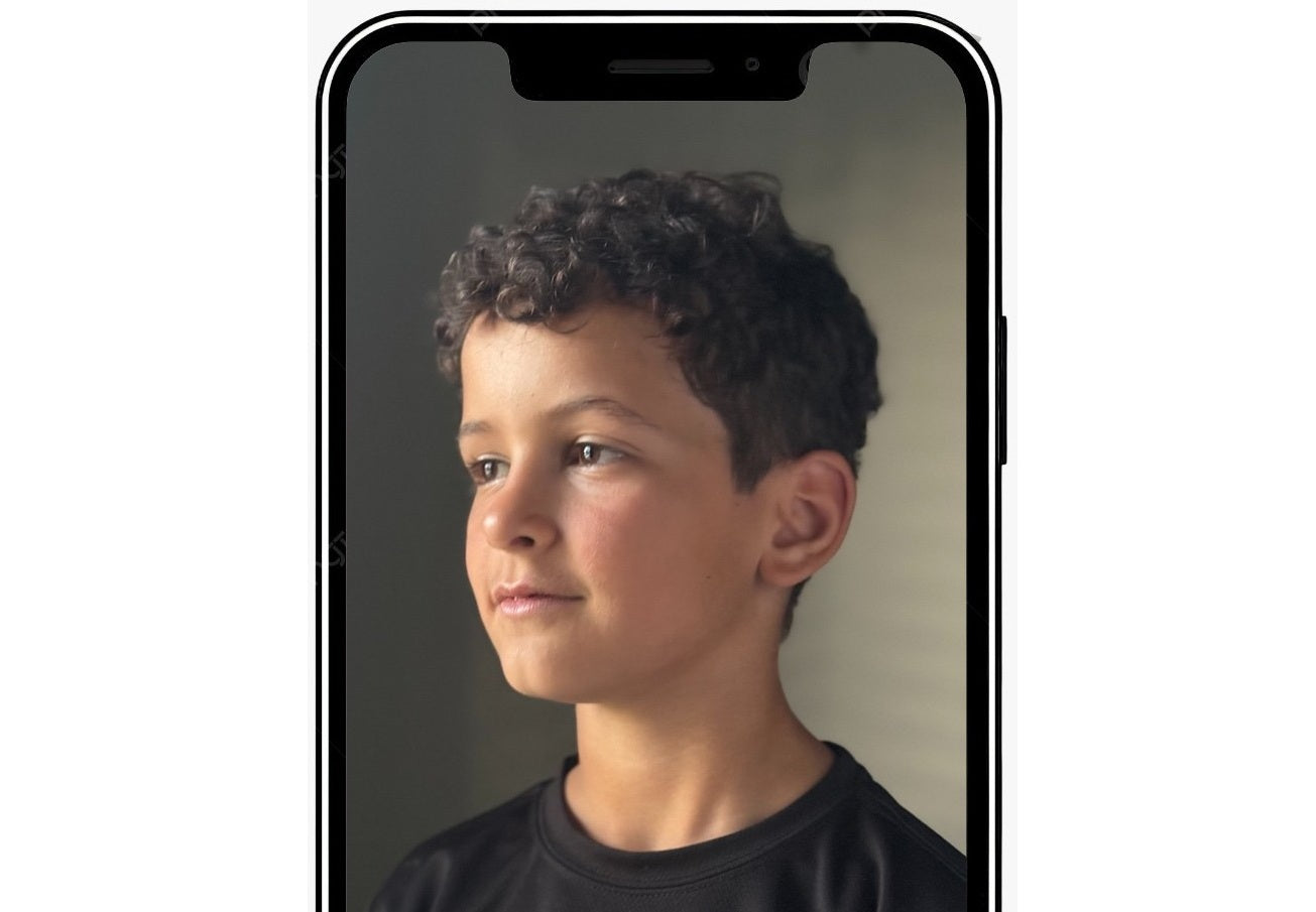 Phone displaying a portrait of a young boy with a neutral background