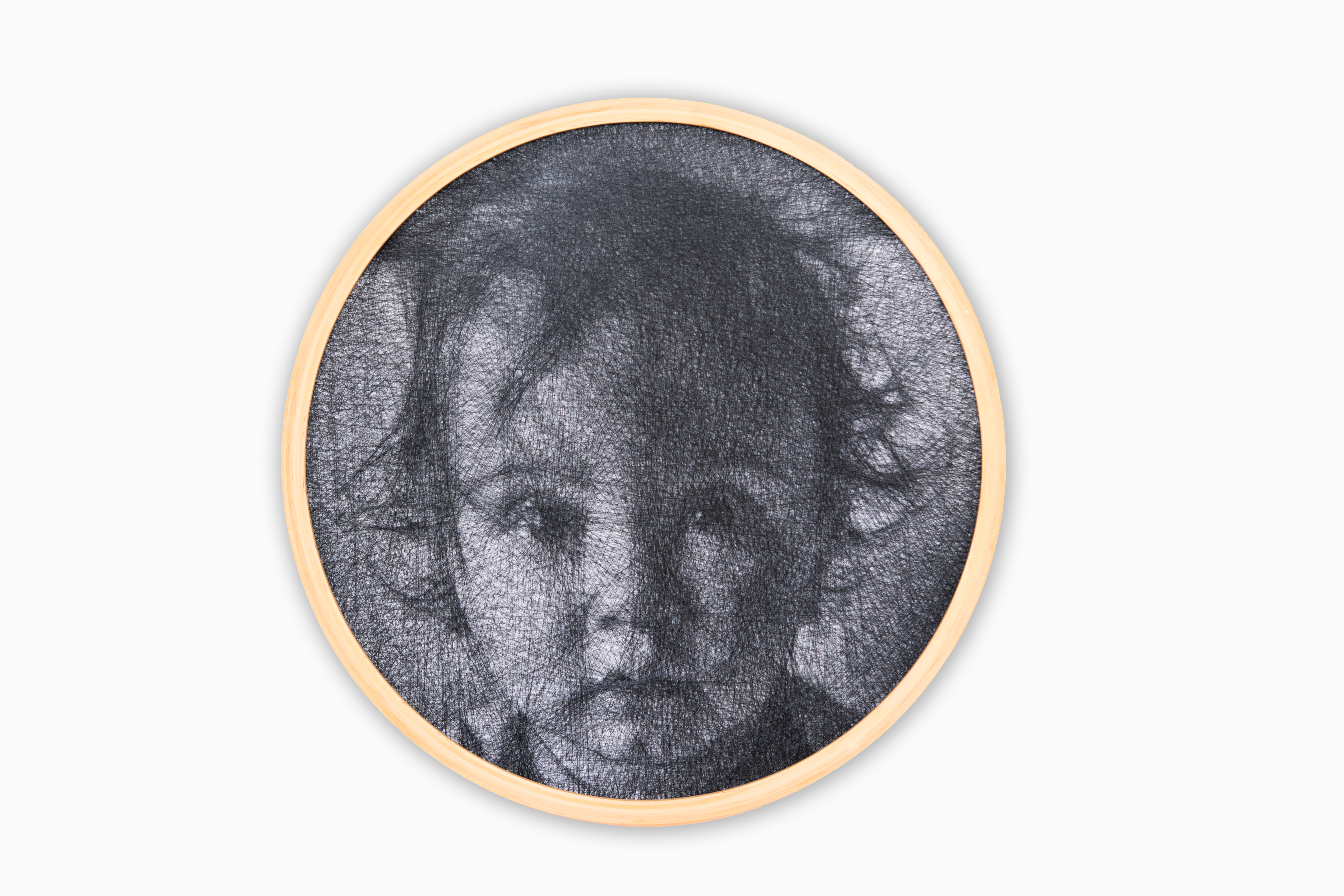 Circular framed artwork of a baby's face on a white background