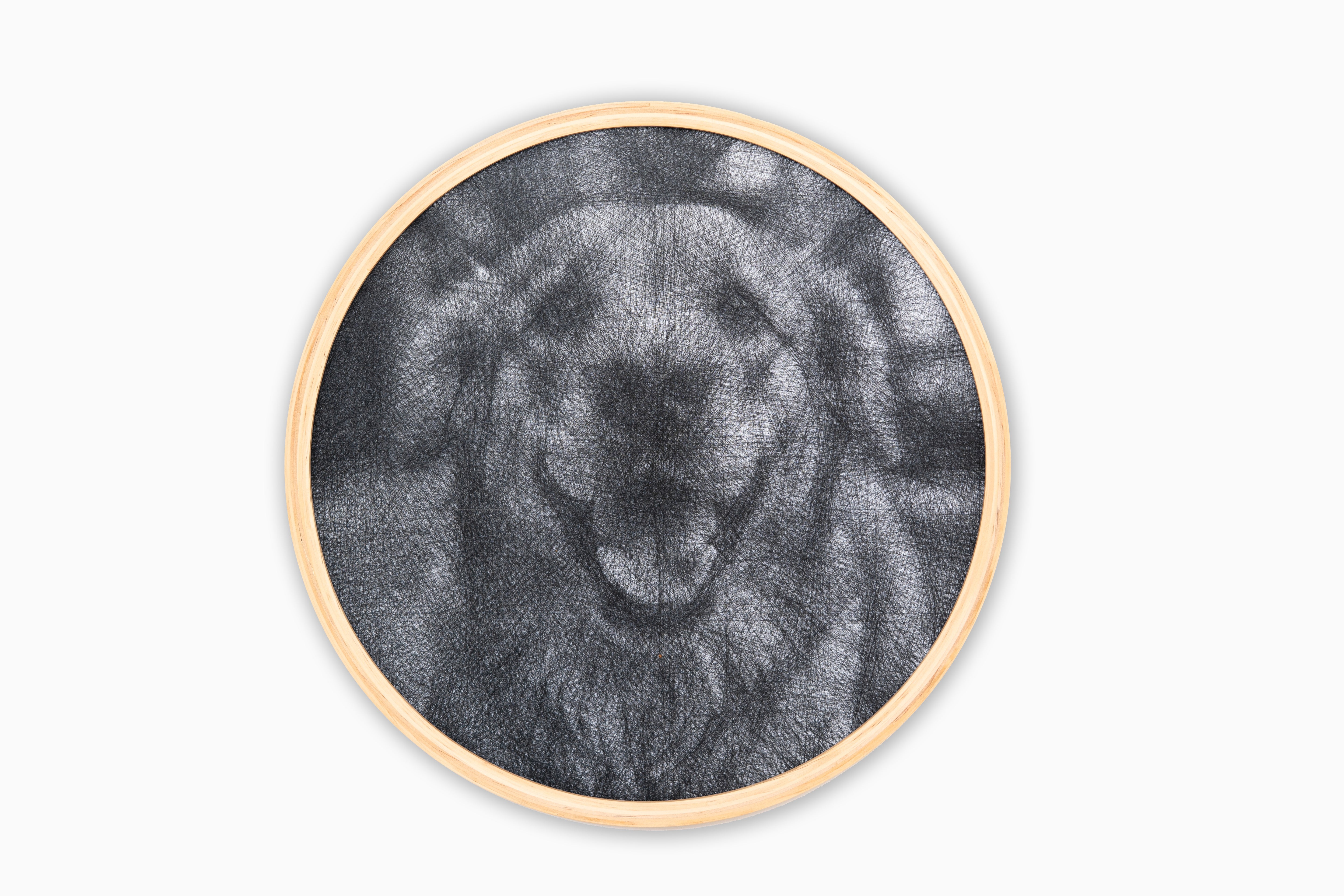 Circular wall art with a black and white abstract design of a dog on a white background